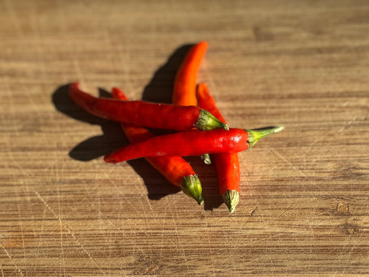 Red chili peppers on a wooden surface