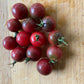 Cluster of red and purple tomatoes on a wooden surface